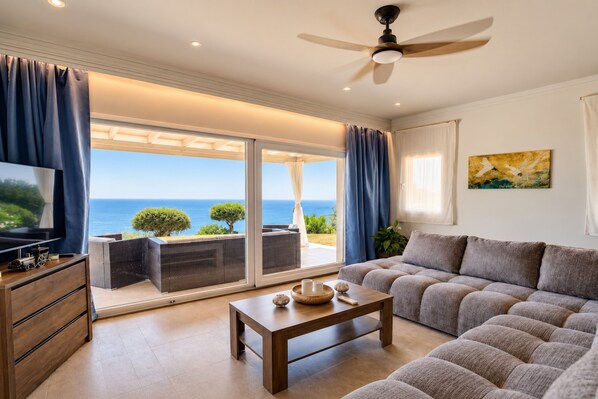 A modern living room with a sofa, a coffee table, and a television.