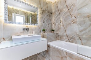 Bathtub, hair dryer, towels, toilet paper