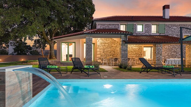 A pool with lounge chairs and a stone building with a tiled roof. - Amazing home in Sajini (Sajini)