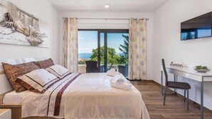 Una camera da letto con un letto, una scrivania, una sedia, una TV e vista sull'esterno.