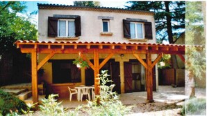 A rustic wooden house with a covered patio, a dining table, and chairs. - 2-bedroom gîte for 5 to 7 people in Sarlat. Heated swimming pool. Free WIFI. (SARLAT LA CANEDA)