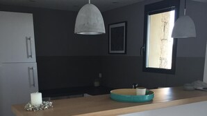 A modern kitchen with a wooden countertop, a sink, and pendant lighting. - EXCEPTIONAL VIEW PINARELLO BAY AND NEEDLES BAVELLA Private Pool (Zonza)