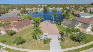 A residential area with houses, a central building with a covered patio, and a large body of water.