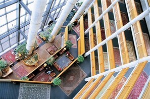 Experience the open and airy lobby with high ceilings, large windows, and comfortable seating areas.