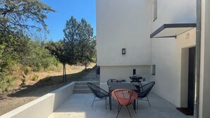 An outdoor patio with a table and chairs, a barbecue grill, and a view of the surrounding landscape. - Family home, large pool – 15 min to Avignon (Villeneuve-Lès-Avignon)