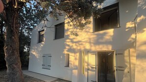 A modern building with a flat roof, large windows, and a door with glass panels. - Family home, large pool – 15 min to Avignon (Villeneuve-Lès-Avignon)