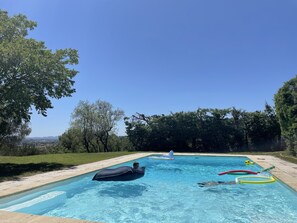 Ein rechteckiger Swimmingpool mit klarem, blauem Wasser, umgeben von einer Betonplattform.