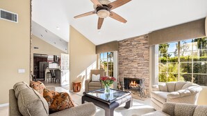 Un salón amplio con chimenea, asientos cómodos y vistas al exterior.