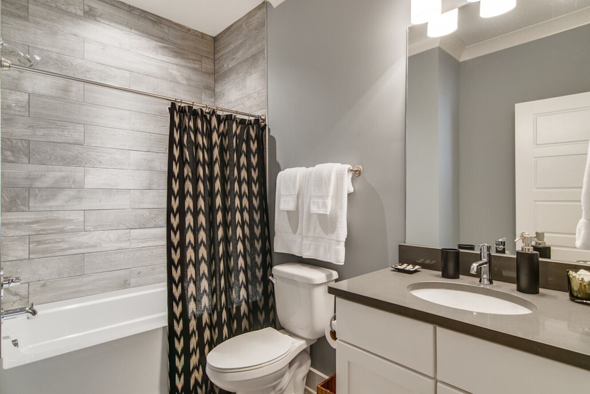 Un baño con cortina de ducha, inodoro, lavabo y espejo.