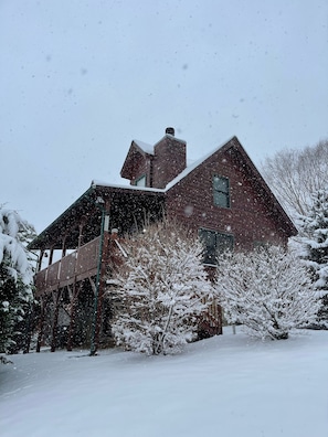 A wooden cabin with a snow-covered roof and a wooden deck. - Sweet Cabin 10 min. away from Ski area (Maggie Valley)