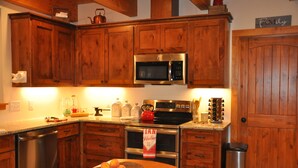 A kitchen with wooden cabinets, stainless steel appliances, and a wooden countertop. - Private Riverfront Lodge with Mountain Views Between Lost Maples and Garner Park (Vanderpool)