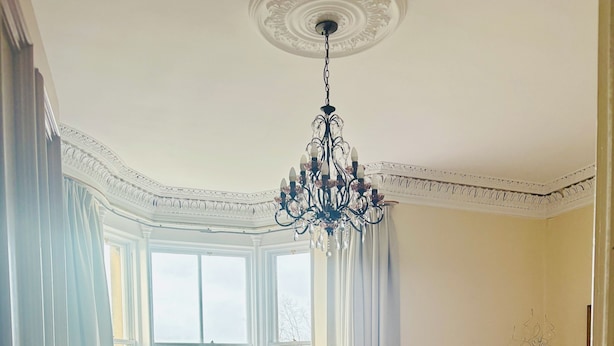 A room with a bed, a sofa, a dining table, and a chandelier. - Heritage house in great location under Stirling castle, close to amenities. (Stirling)