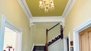 A staircase with a plaid carpet, wooden handrail, and a chandelier. - Heritage house in great location under Stirling castle, close to amenities. (Stirling)