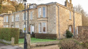 A stone building with multiple windows and a well-maintained lawn. - Heritage house in great location under Stirling castle, close to amenities. (Stirling)