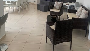 Ein modernes Wohnzimmer mit Essbereich, grauen Sofas und einem weißen Esstisch.