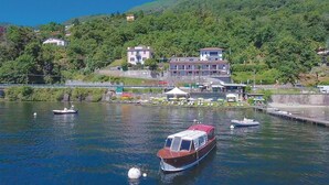 A boat docked at a marina with buildings and greenery in the background. - 1 bedroom gorgeous apartment in Oggebbio (VB) (Oggebbio (VB))