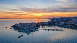 A coastal cityscape at sunset with a marina and buildings along the waterfront. - Awesome home in Srinjine (Srinjine)