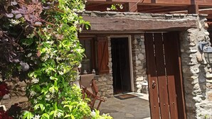 A rustic building with a stone facade, wooden shutters, and a wooden pergola with flowers. - Luxury Traditional Stone House in Vrasna (Vrasna)