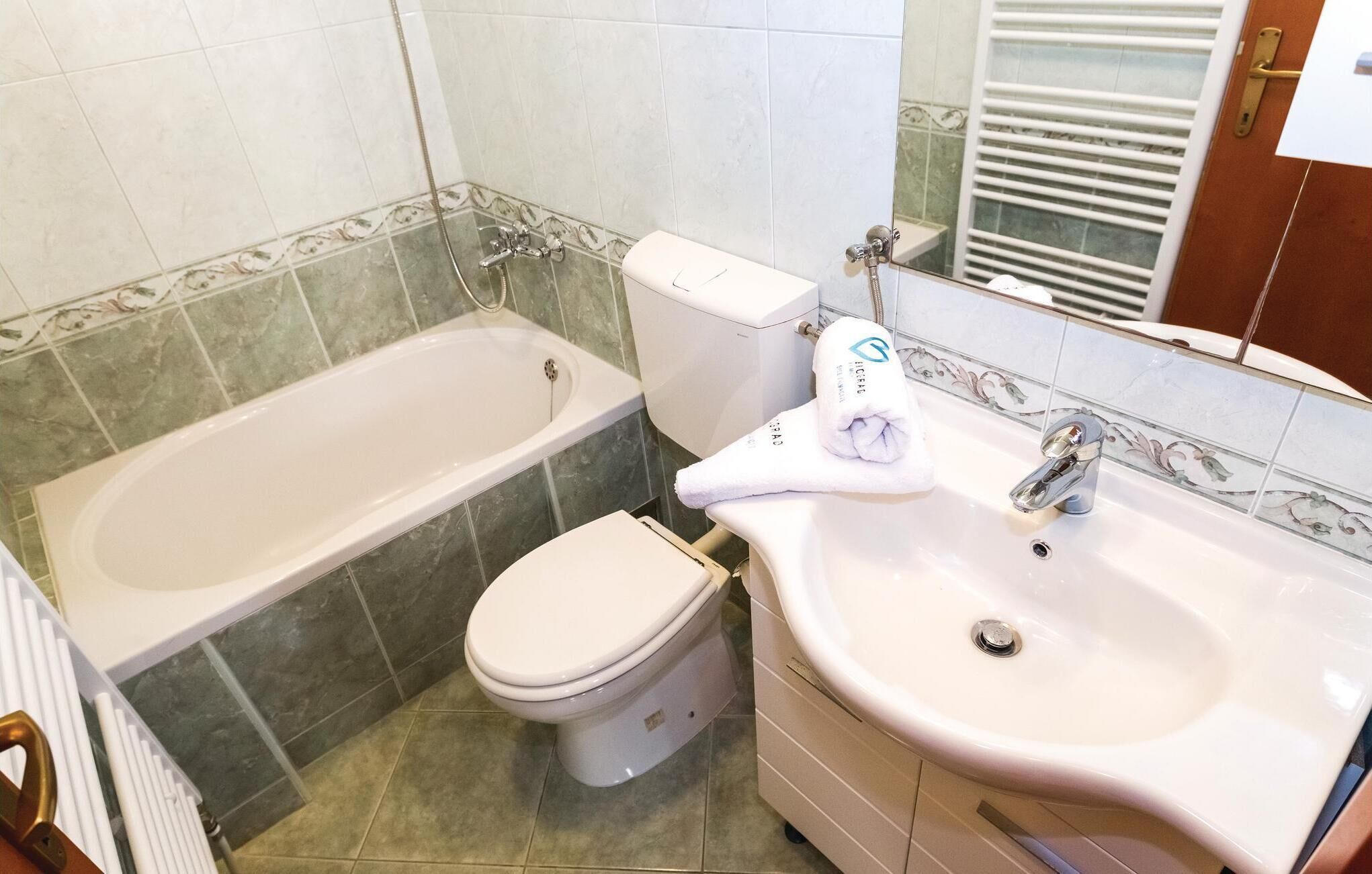 A bathroom with a bathtub, toilet, and sink.