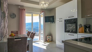 Una cocina moderna con comedor, ventanas amplias y vistas a las montañas.