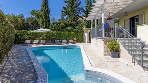A swimming pool with lounge chairs, a pergola, and a staircase leading to a building. - Stunning home in Opatija with sauna (Opatija)
