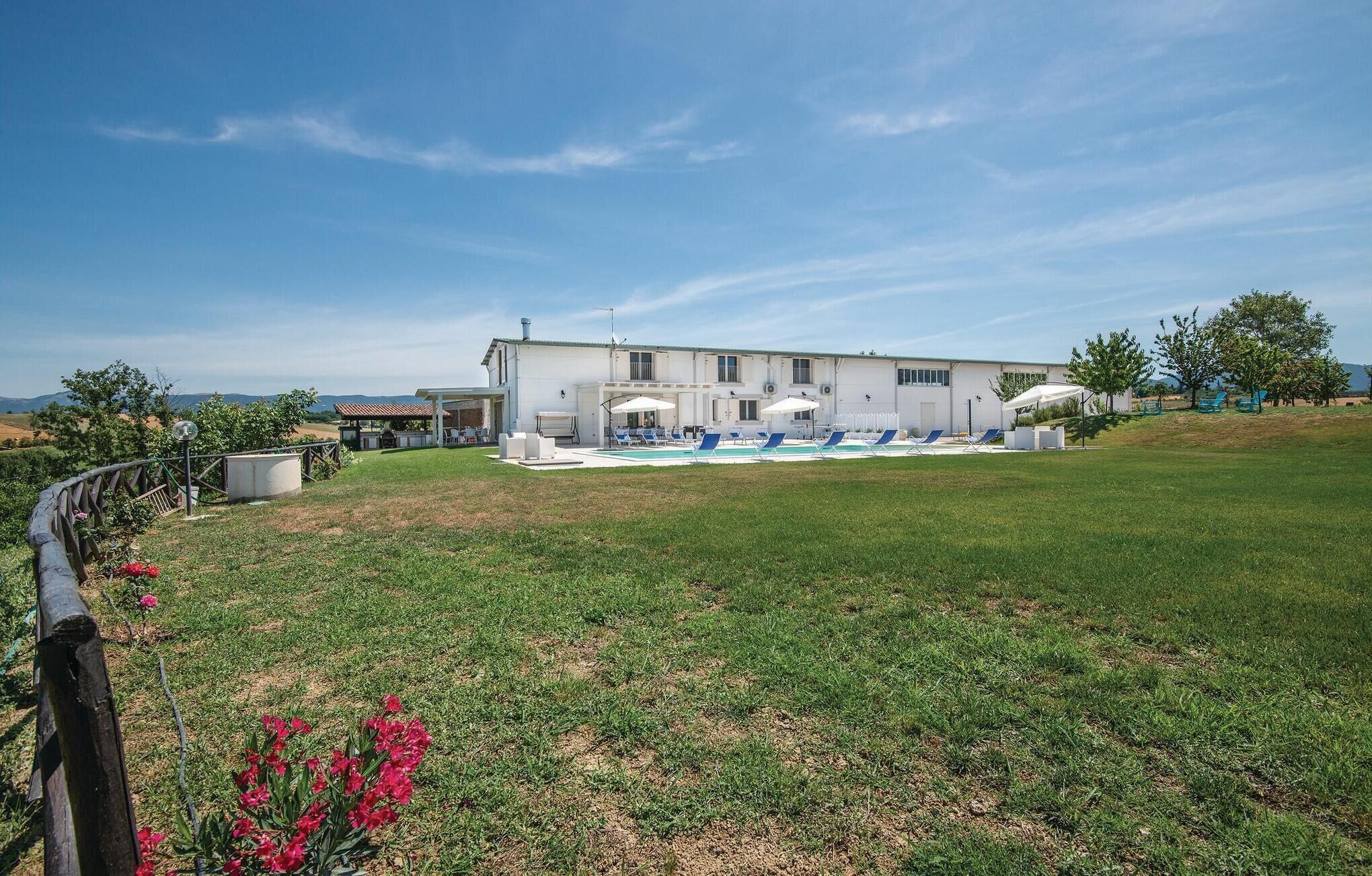 A modern two-story building with a swimming pool and outdoor seating area.