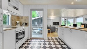 A modern kitchen with a checkered floor, a built-in oven, and a large window.