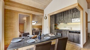 Una cocina moderna con gabinetes de madera oscura, horno empotrado y microondas.