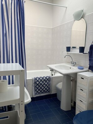 Ein Badezimmer mit Badewanne, Waschbecken und Spiegel.
