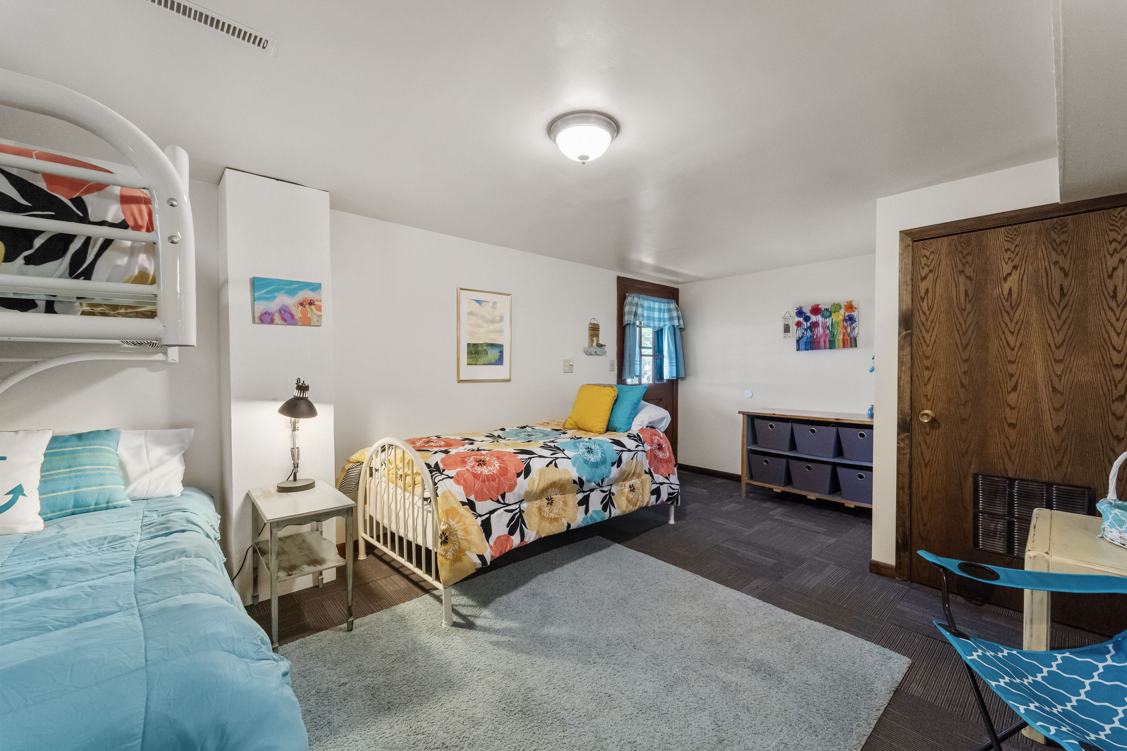 Ein Schlafzimmer mit einem Etagenbett, einem Schreibtisch, einem Stuhl und einem Kleiderschrank.