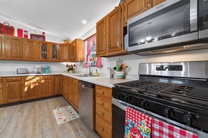 Une cuisine avec des meubles en bois, une cuisinière en acier inoxydable et un four à micro-ondes.