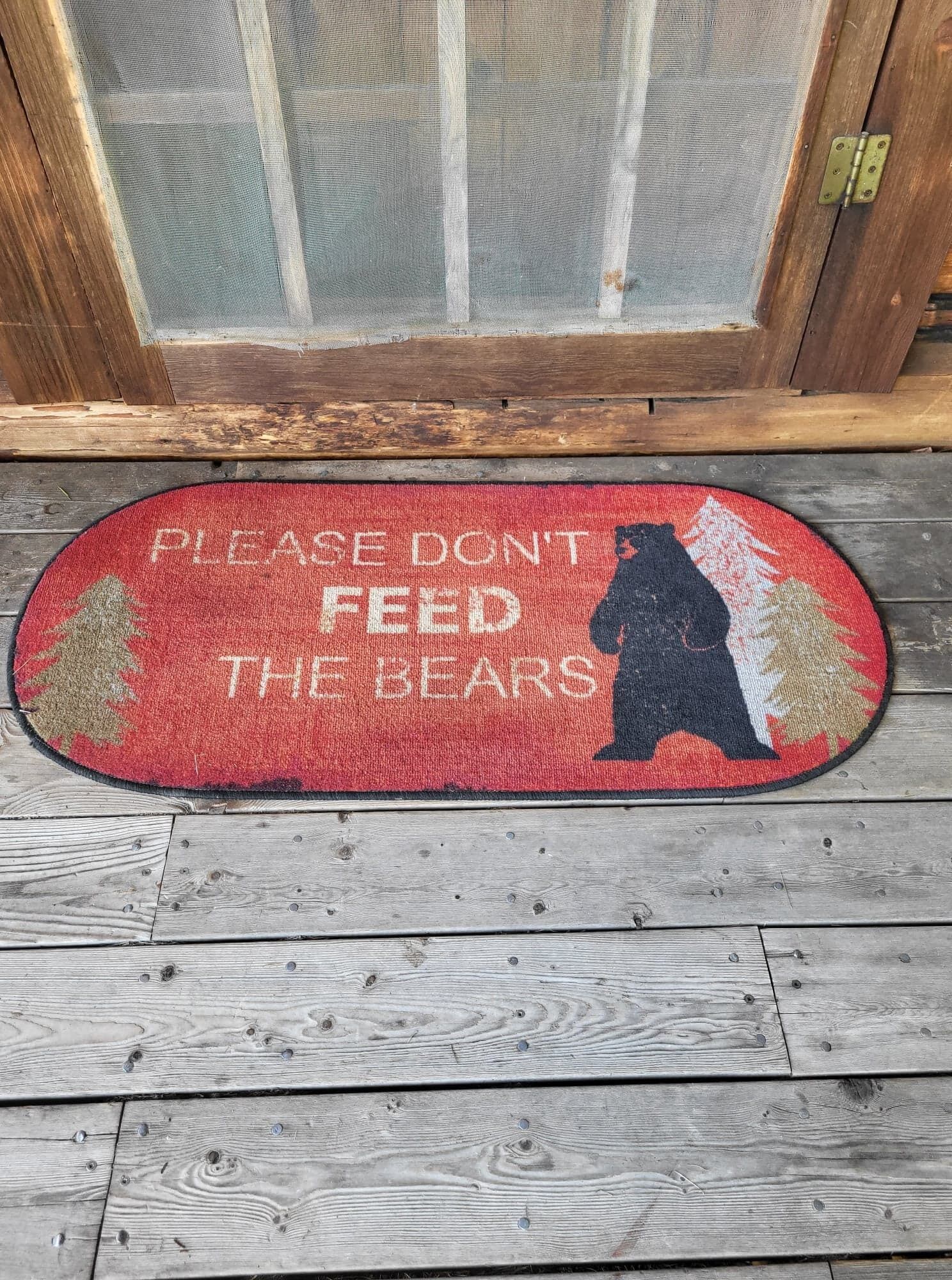Een deurmat met een bergensilhouet en de tekst 'PLEASE DON'T FEED THE BEARS'.