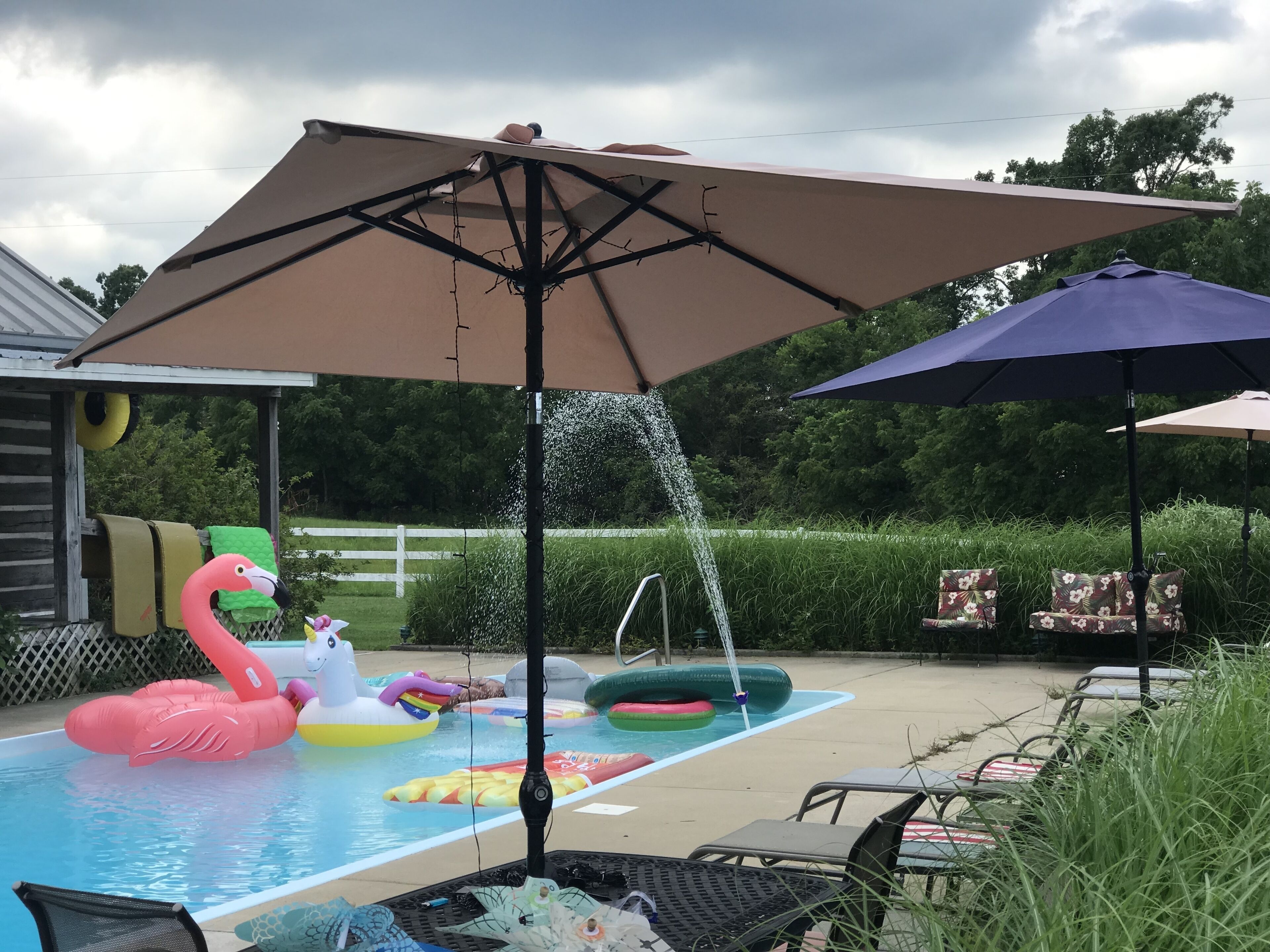 Une piscine avec des jeux gonflables et une fontaine.
