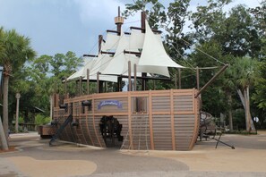A pirate-themed play structure with climbing steps and a slide.