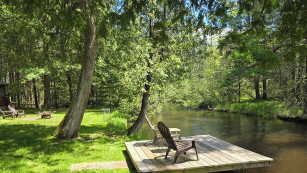 A wooden dock extending into a river surrounded by lush greenery and trees. - A Perfect Northern Get-Away On The Scenic Big Creek In Luzerne (Luzerne)