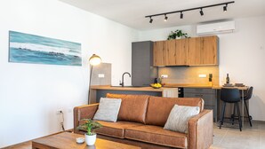 Ein modernes Wohnzimmer mit einem braunen Ledersofa, einem Holztisch und einem Bild an der Wand.