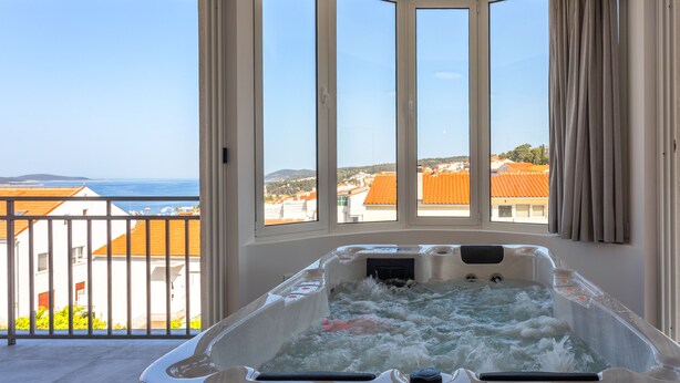 Ein Whirlpool mit Blick auf das Meer und die Gebäude.