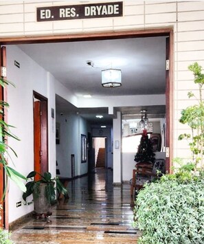 A hallway with a sign reading 'ED. RES. DRYADE,' leading to a room with a Christmas tree.