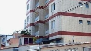 A multi-story building with balconies and a gated entrance. - Wi-fi, 2 bedrooms (one en-suite) and 2 bathrooms near the sea. (Praia Grande)