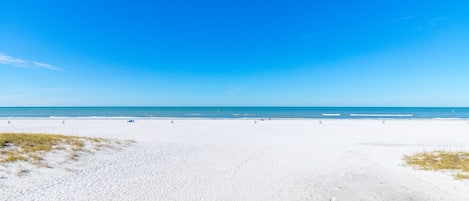 Na praia, espreguiçadeiras, toalhas de praia 