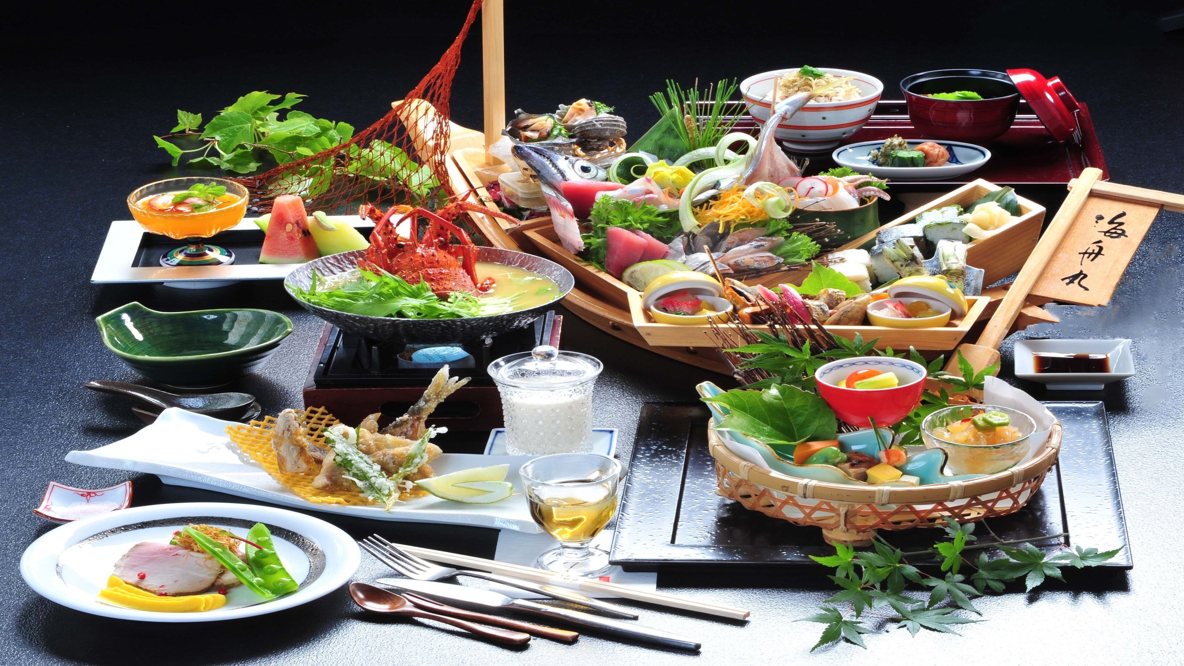 A variety of dishes and food items, including seafood, vegetables, and a hot pot, arranged on a table with chopsticks, bowls, and a teapot.