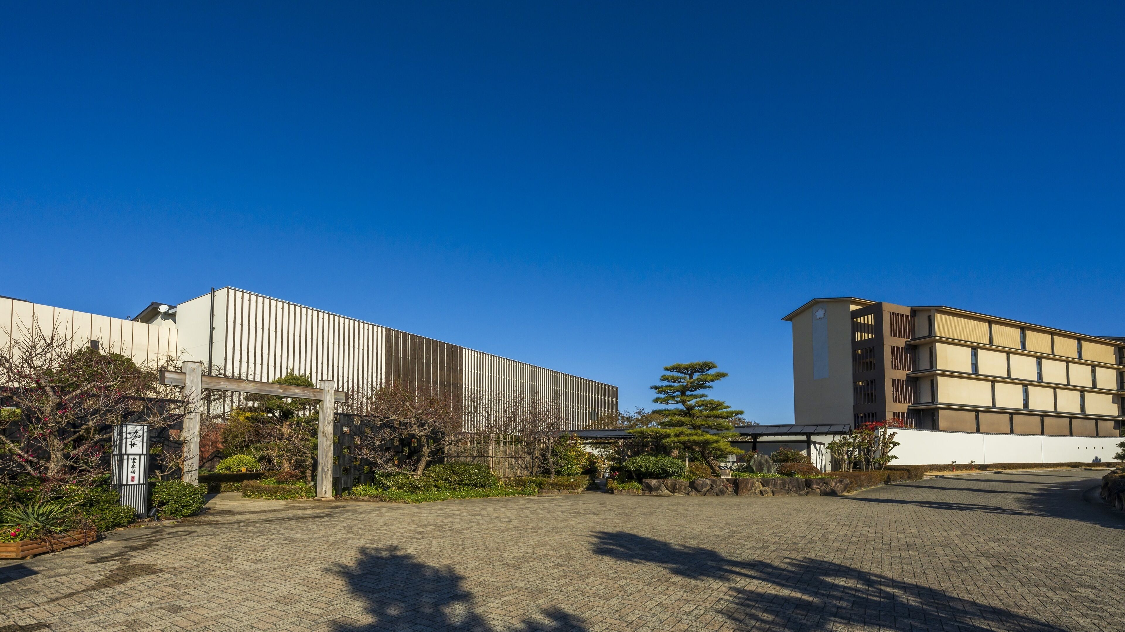 A building with a modern design, featuring a flat roof and a series of vertical panels.