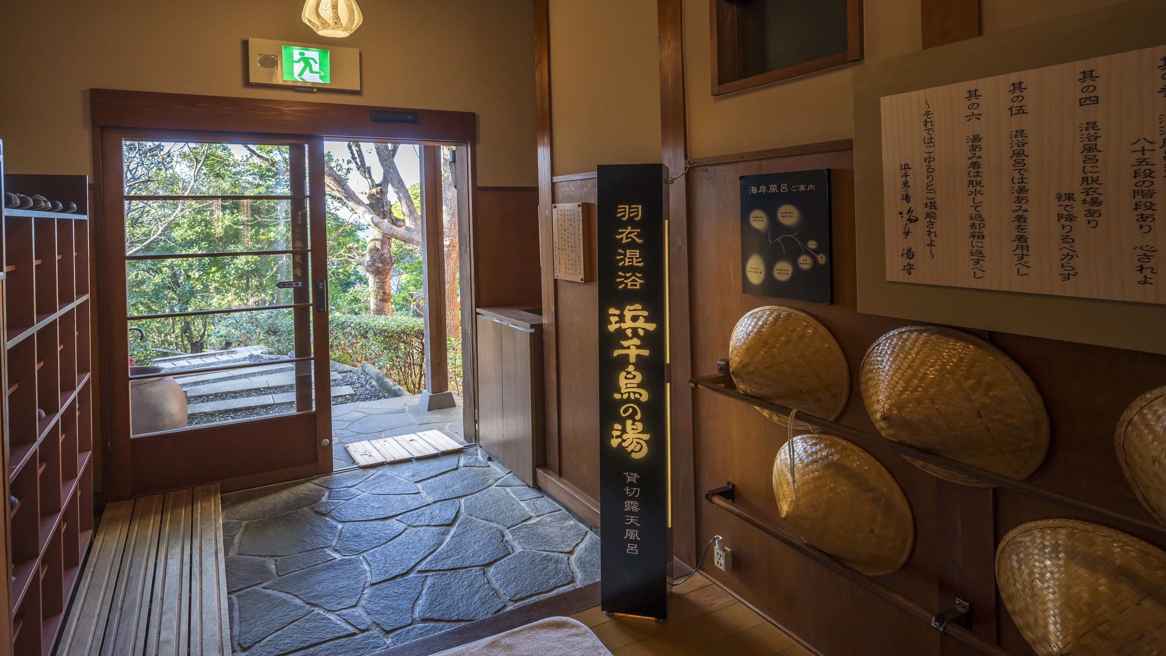 Une entrée de style japonais traditionnel, avec un chemin de pierres menant à l’extérieur.
