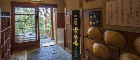 Une entrée de style japonais traditionnel, avec un chemin de pierres menant à l’extérieur.