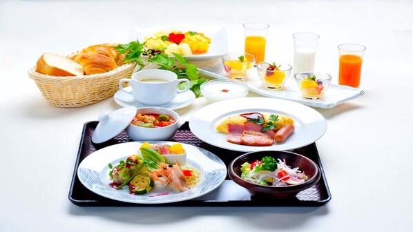 Bandeja de desayuno con diferentes platos, incluyendo huevos, jamón y ensalada.