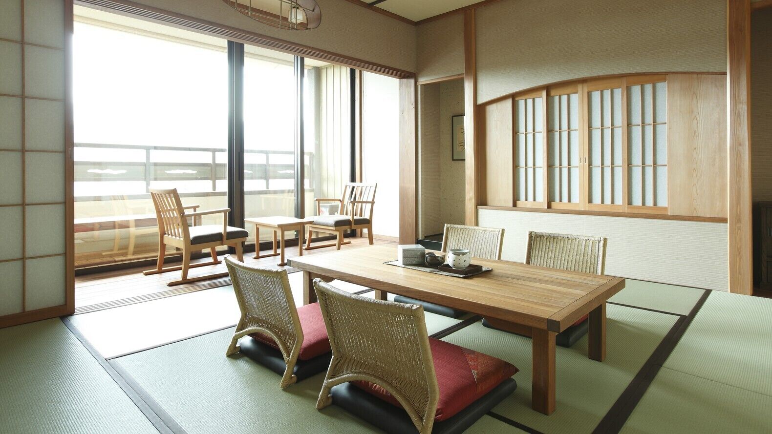 A traditional Japanese room with tatami flooring, a low wooden table, and shoji screens.