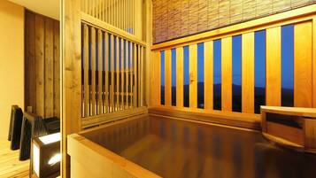 A traditional Japanese onsen with wooden railings and a view of mountains.