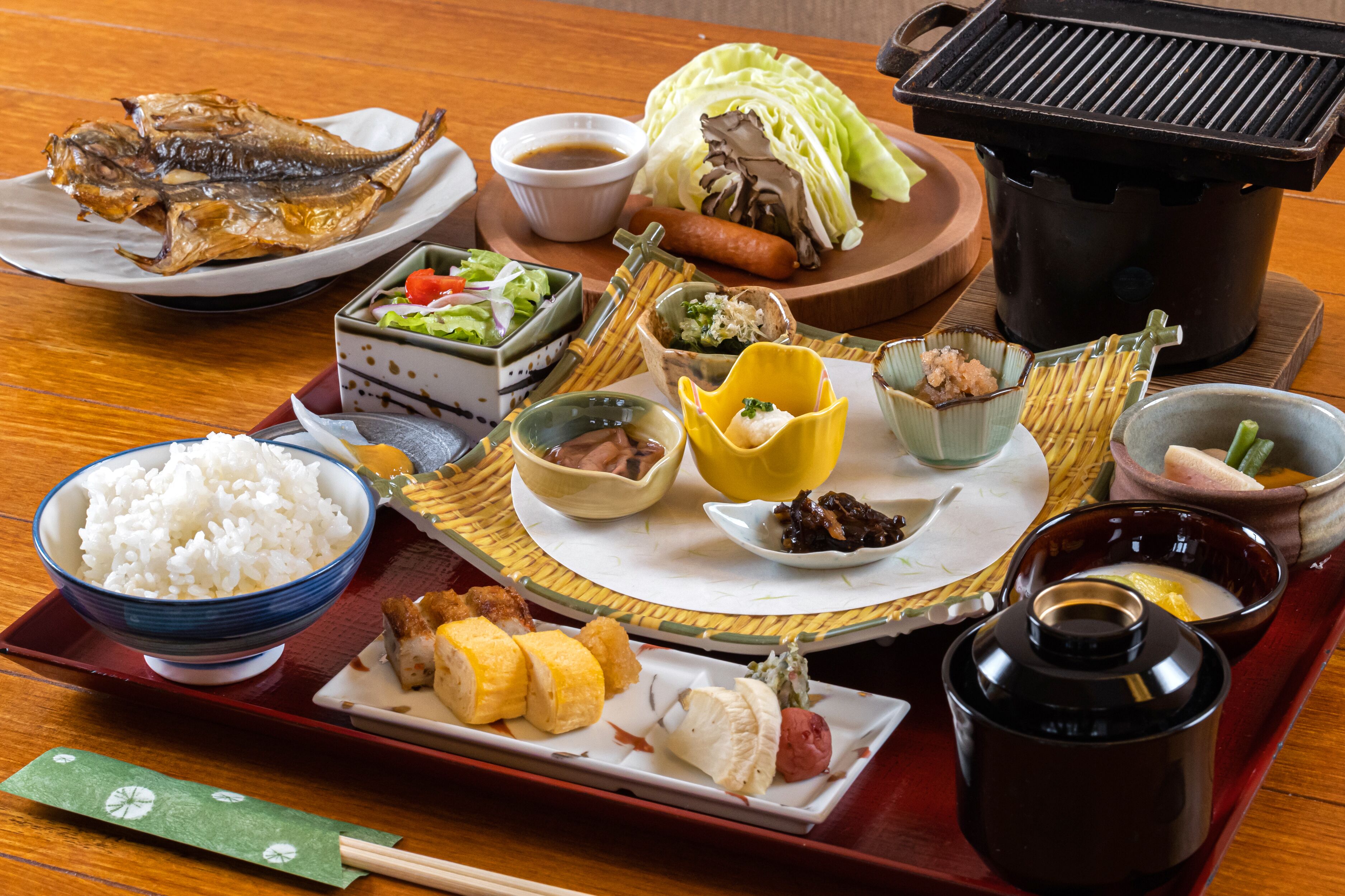 Un repas japonais traditionnel composé de différents plats, notamment du poisson, du riz et des légumes.