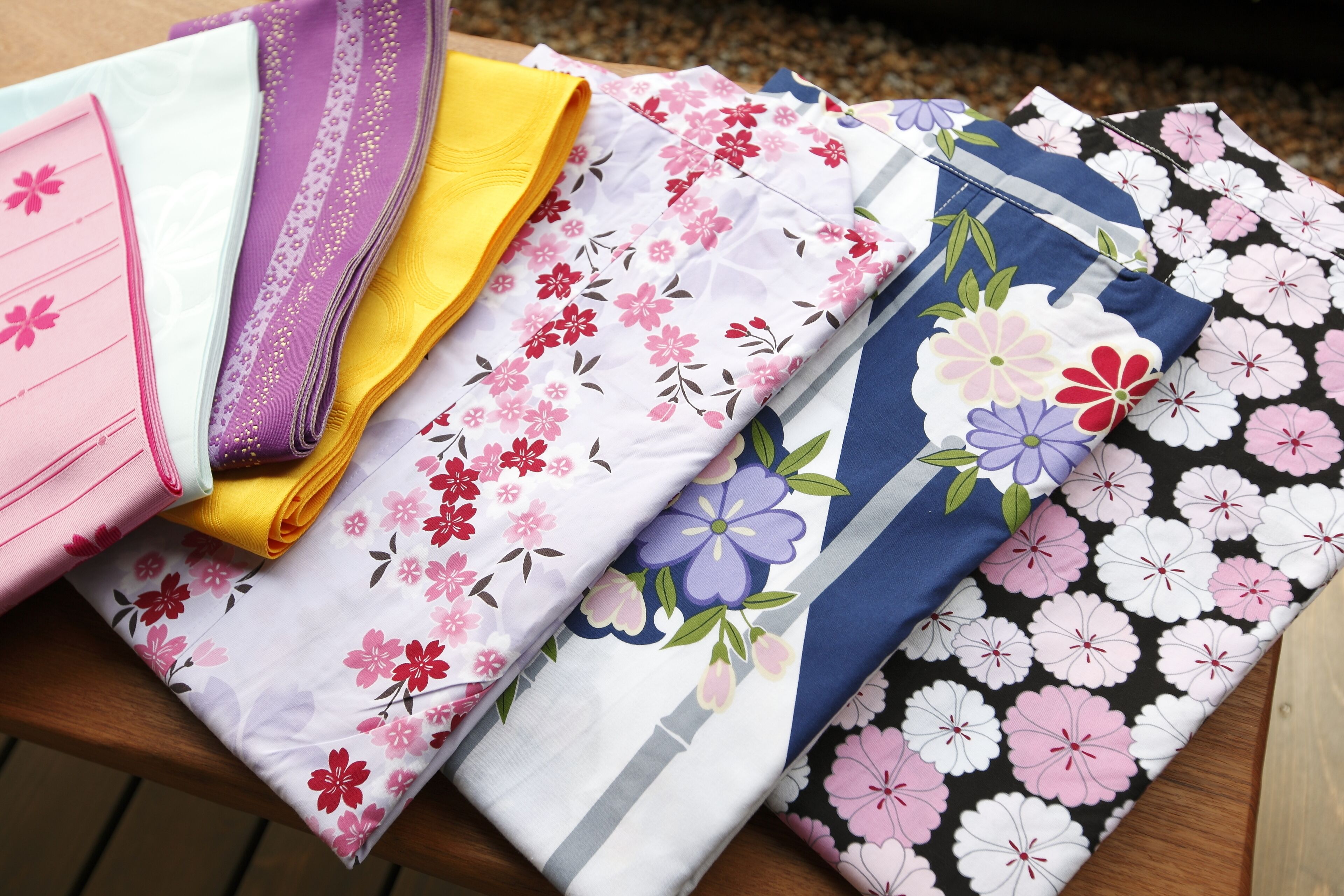 Verschiedene Stoffe mit floralen Mustern, ordentlich zusammengefaltet.