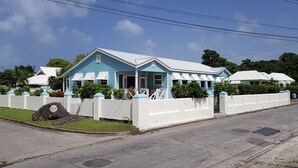 Un edificio de dos pisos con fachada azul y blanca, una valla blanca y un letrero que dice 'Daytona Court'.